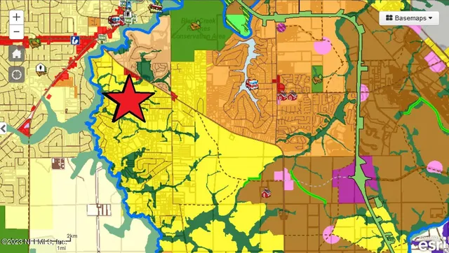 a view of a field with a trees in the background