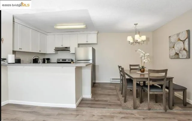 a kitchen with kitchen island granite countertop a table chairs sink and cabinets
