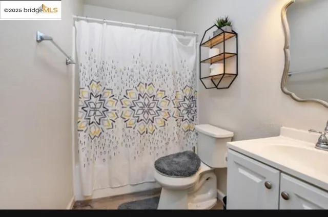 a bathroom with a toilet and a shower curtain