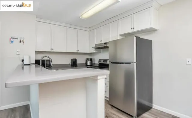 a kitchen with stainless steel appliances granite countertop white refrigerator stove a microwave and cabinets
