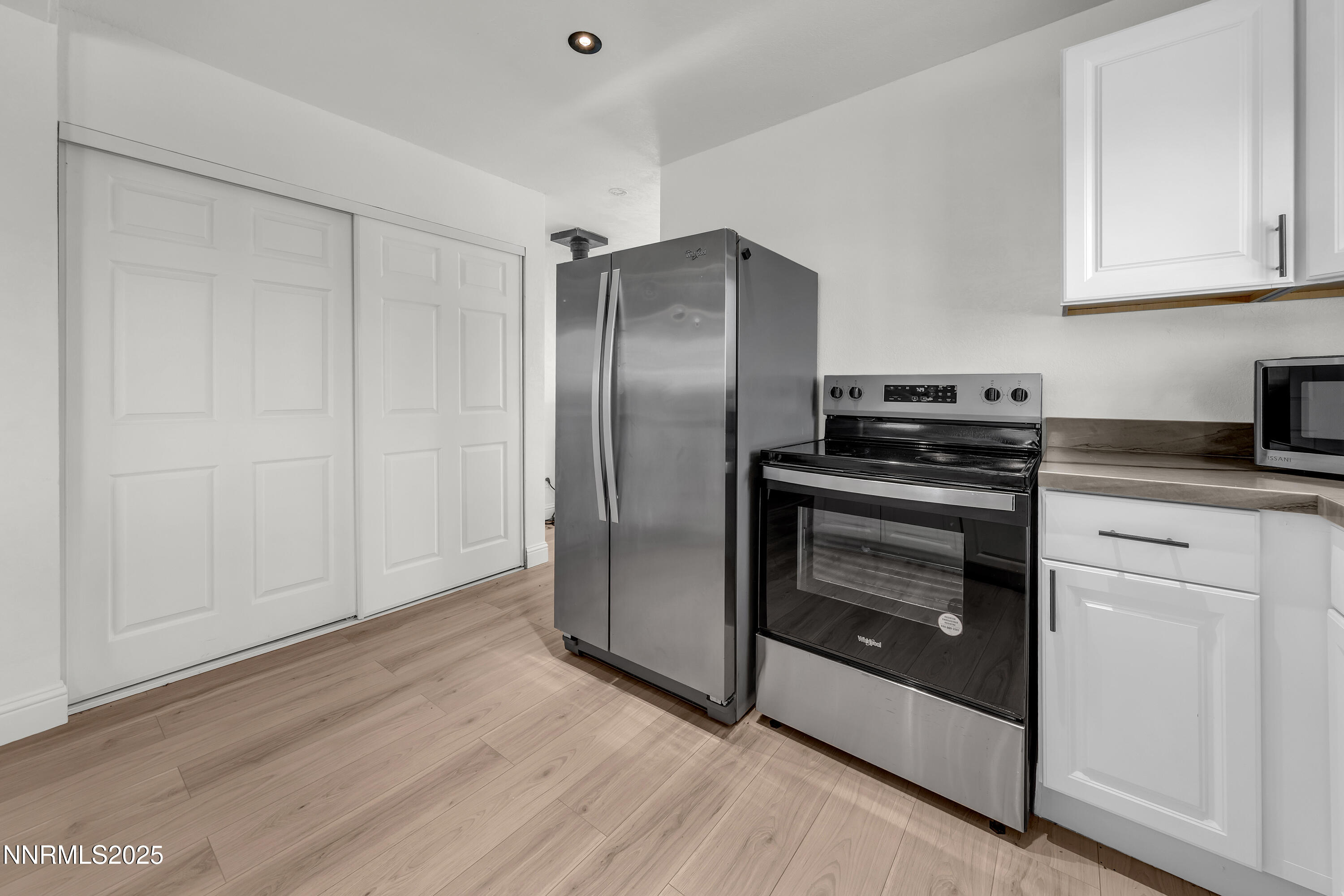 15725 Toll Road Reno, NV 89521 - Photo 11 of 27 a kitchen with granite countertop a refrigerator stove and white cabinets