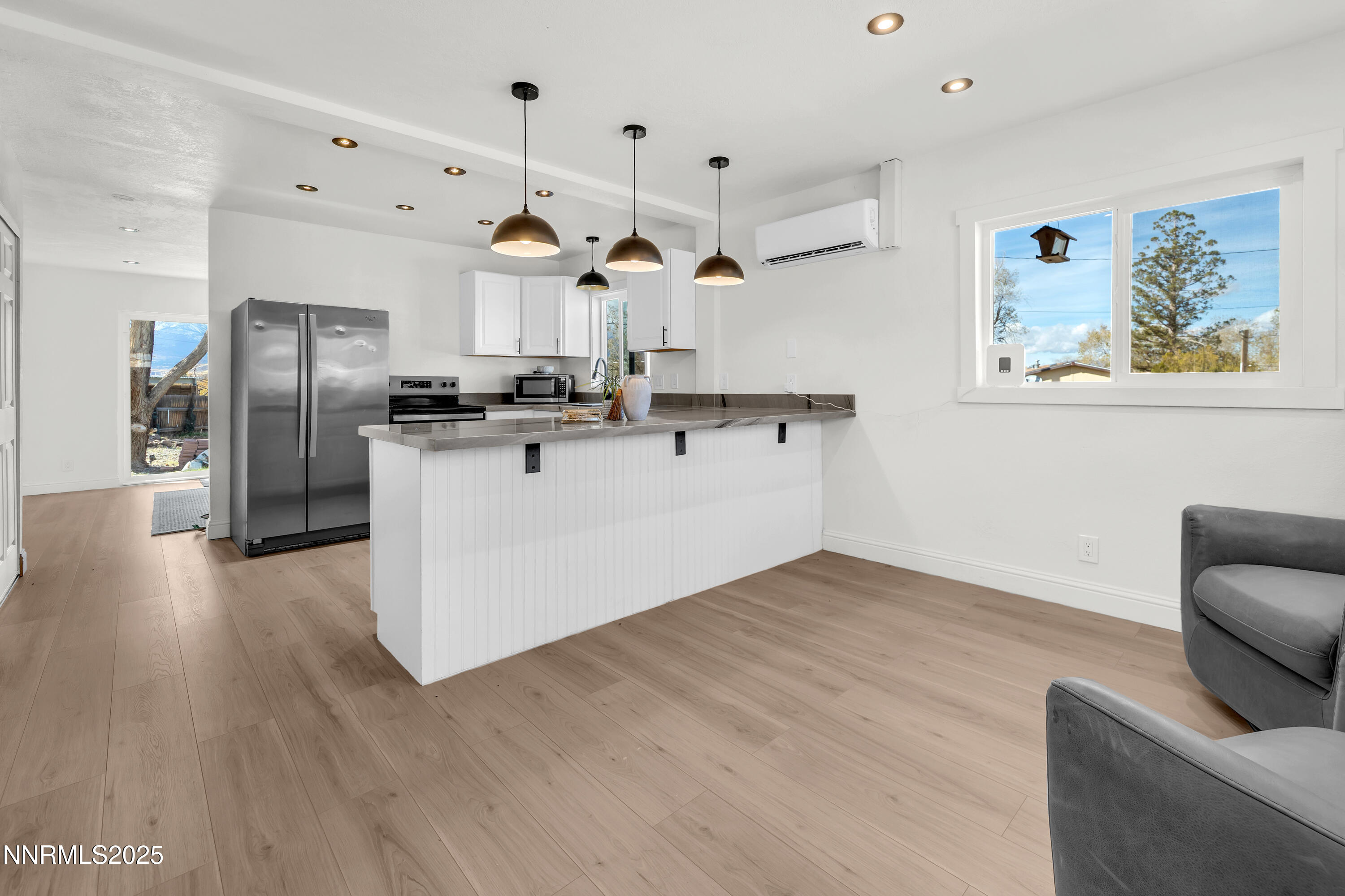 15725 Toll Road Reno, NV 89521 - Photo 4 of 27 a kitchen with stainless steel appliances kitchen island wooden floors cabinets and wooden floor