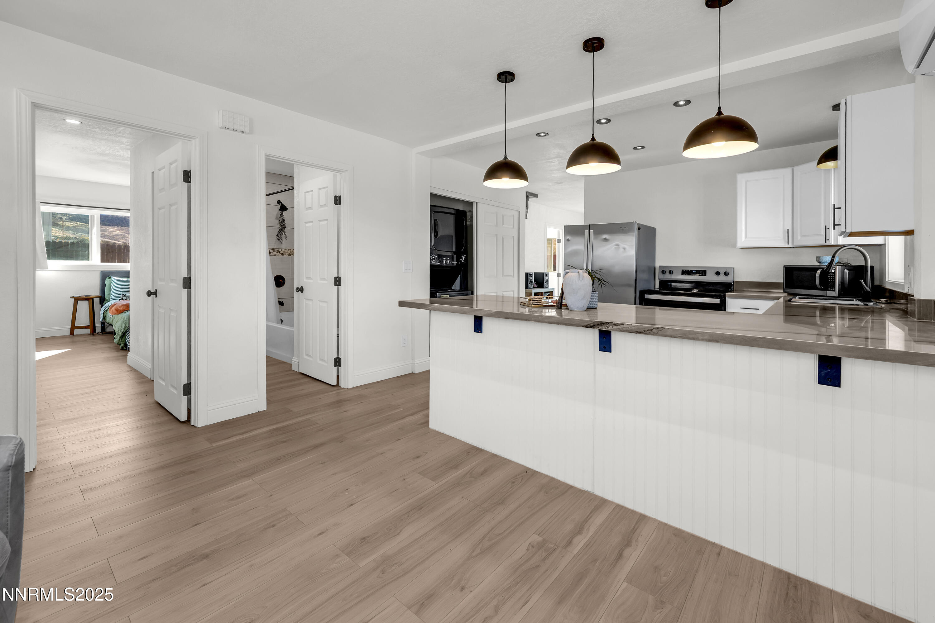 15725 Toll Road Reno, NV 89521 - Photo 6 of 27 a view of a kitchen with kitchen island stainless steel appliances wooden floor and living room view