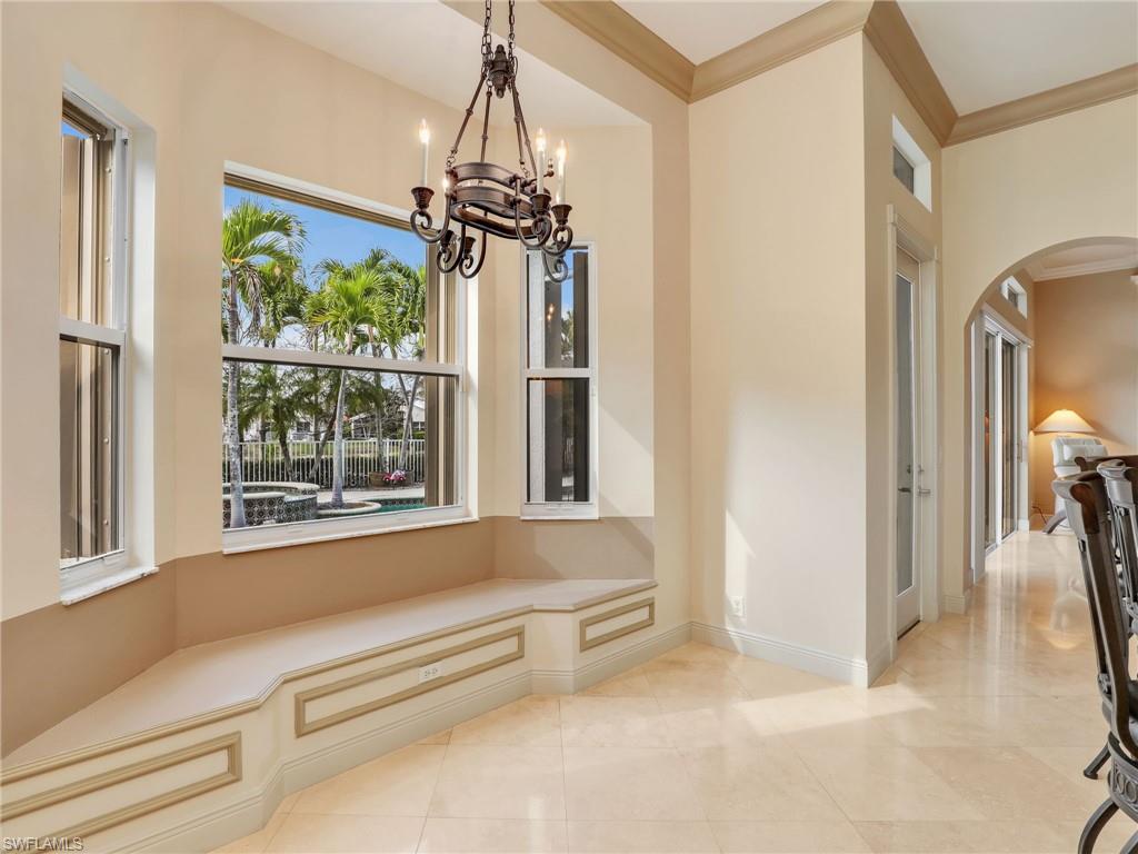 9241 Springview Loop Estero, FL 33928 - Photo 12 of 41 Unfurnished dining area featuring ornamental molding, arched walkways, and hanging lights