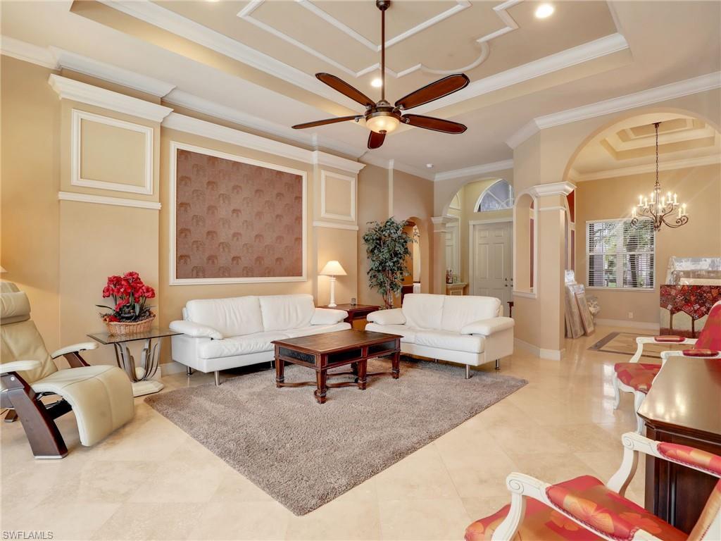 9241 Springview Loop Estero, FL 33928 - Photo 6 of 41 Living area with arched walkways, ceiling fan, suspended lighting, a raised ceiling, and ornate columns