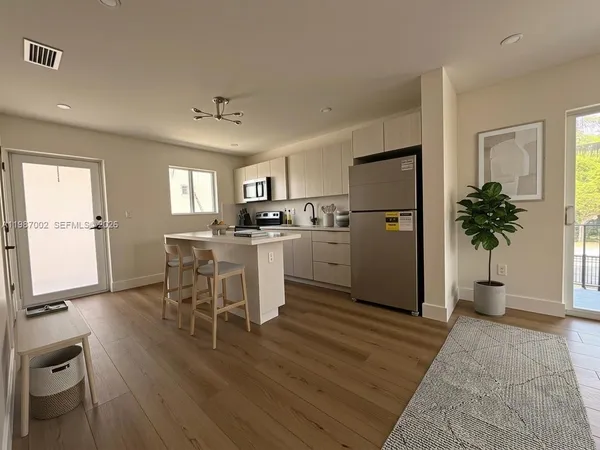 a kitchen with a sink a counter top space appliances and cabinets