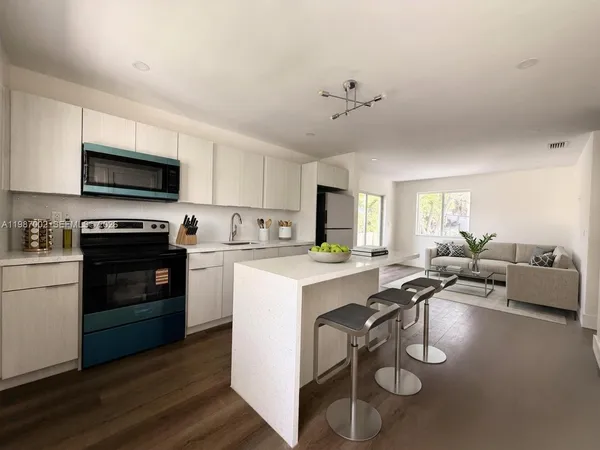 a kitchen with a sink a counter top space appliances and cabinets