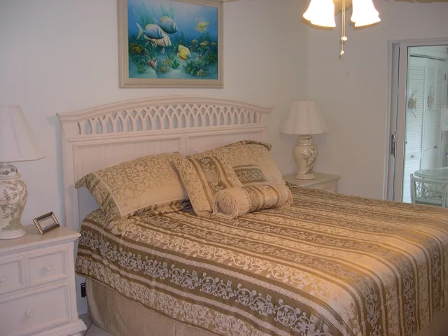 a bedroom with a bed and a painting on the wall