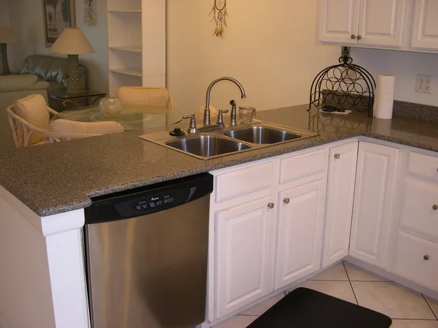 a kitchen with granite countertop white cabinets and a stove