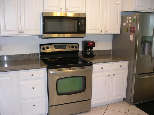 a kitchen with stainless steel appliances granite countertop a stove a microwave and a refrigerator