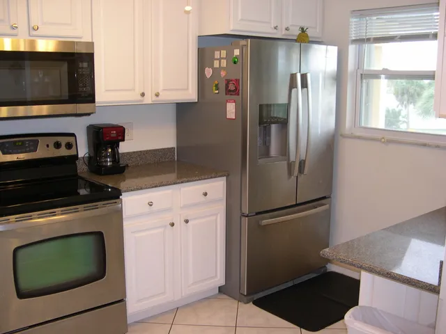 a kitchen with stainless steel appliances granite countertop a refrigerator sink and stove