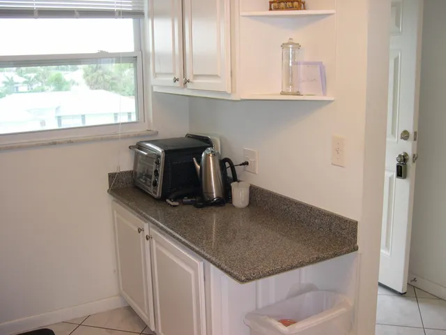 a kitchen with stainless steel appliances granite countertop a sink and a window
