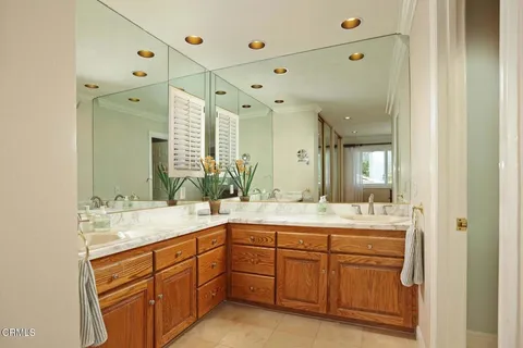 a spacious bathroom with a sink double vanity granite and a mirror