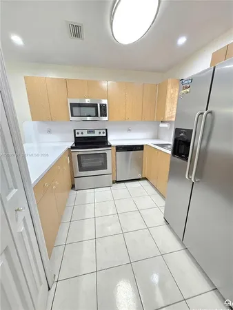 a kitchen with granite countertop a stove a sink a microwave a counter top space and cabinets