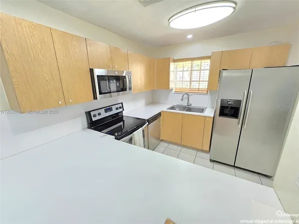 a kitchen with stainless steel appliances a refrigerator sink and microwave