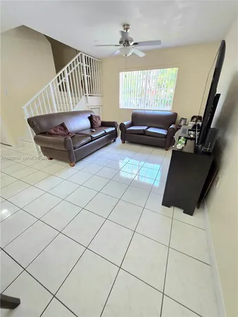 a living room with furniture and a floor to ceiling window