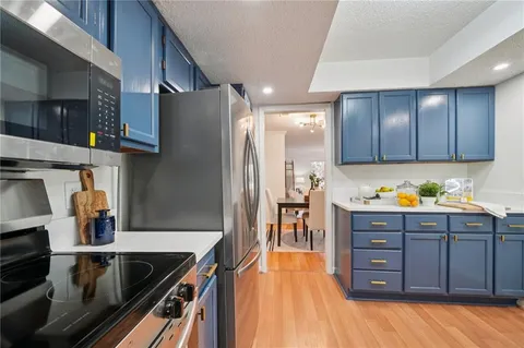 a kitchen with stainless steel appliances granite countertop a refrigerator and a stove top oven