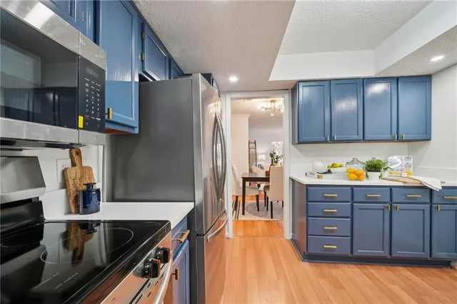 a kitchen with stainless steel appliances granite countertop a refrigerator and a stove top oven