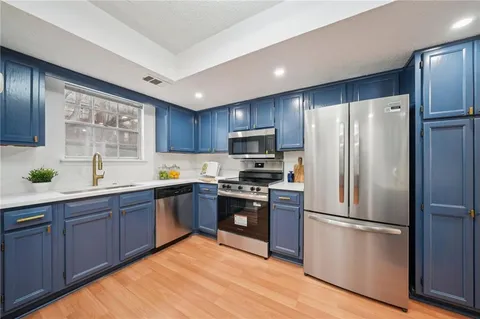 a kitchen with stainless steel appliances granite countertop a refrigerator stove top oven and sink