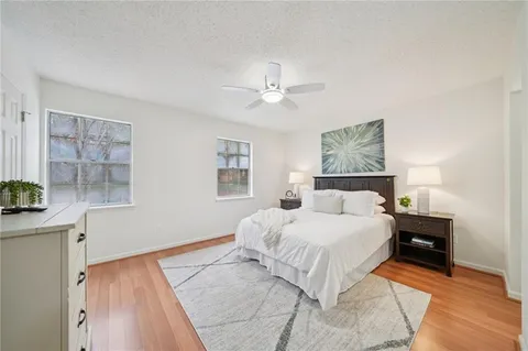 a bedroom with a beds chandelier and a window