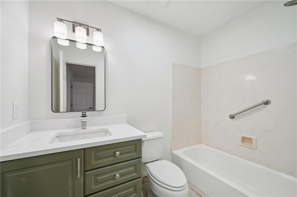 1750 Clairmont Road, Unit 8 Decatur, GA 30033 - Photo 21 of 28 a bathroom with a toilet a sink a mirror a bathtub and vanity