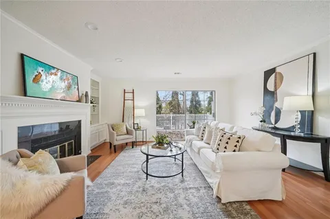 a living room with furniture a fireplace and a large mirror