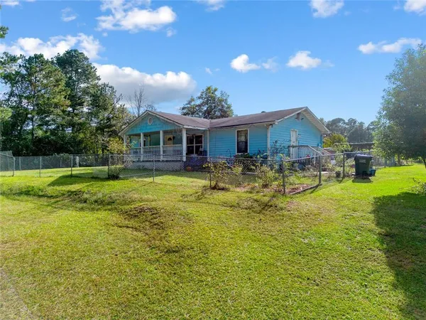 a view of a house with a backyard and a patio