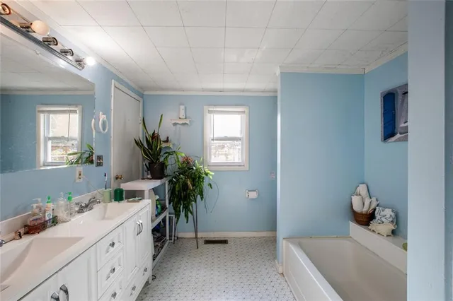 a spacious bathroom with a tub sink and mirror