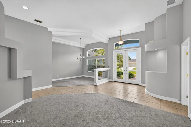 a large kitchen with granite countertop a stove a sink a refrigerator and white cabinets with wooden floor