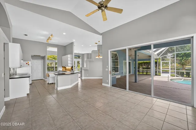 an empty room with a chandelier fan and closet