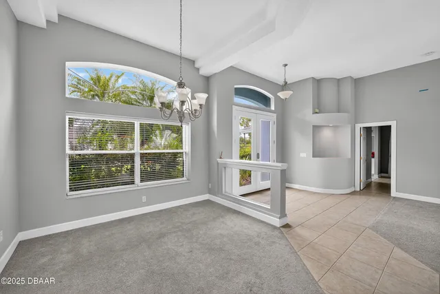 a large white kitchen with granite countertop a large window and stainless steel appliances