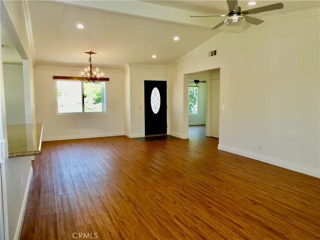 a kitchen with stainless steel appliances granite countertop a refrigerator a stove and a wooden floors