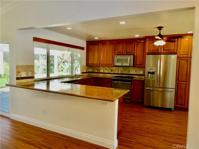 a view of a room with a ceiling fan and wooden floor