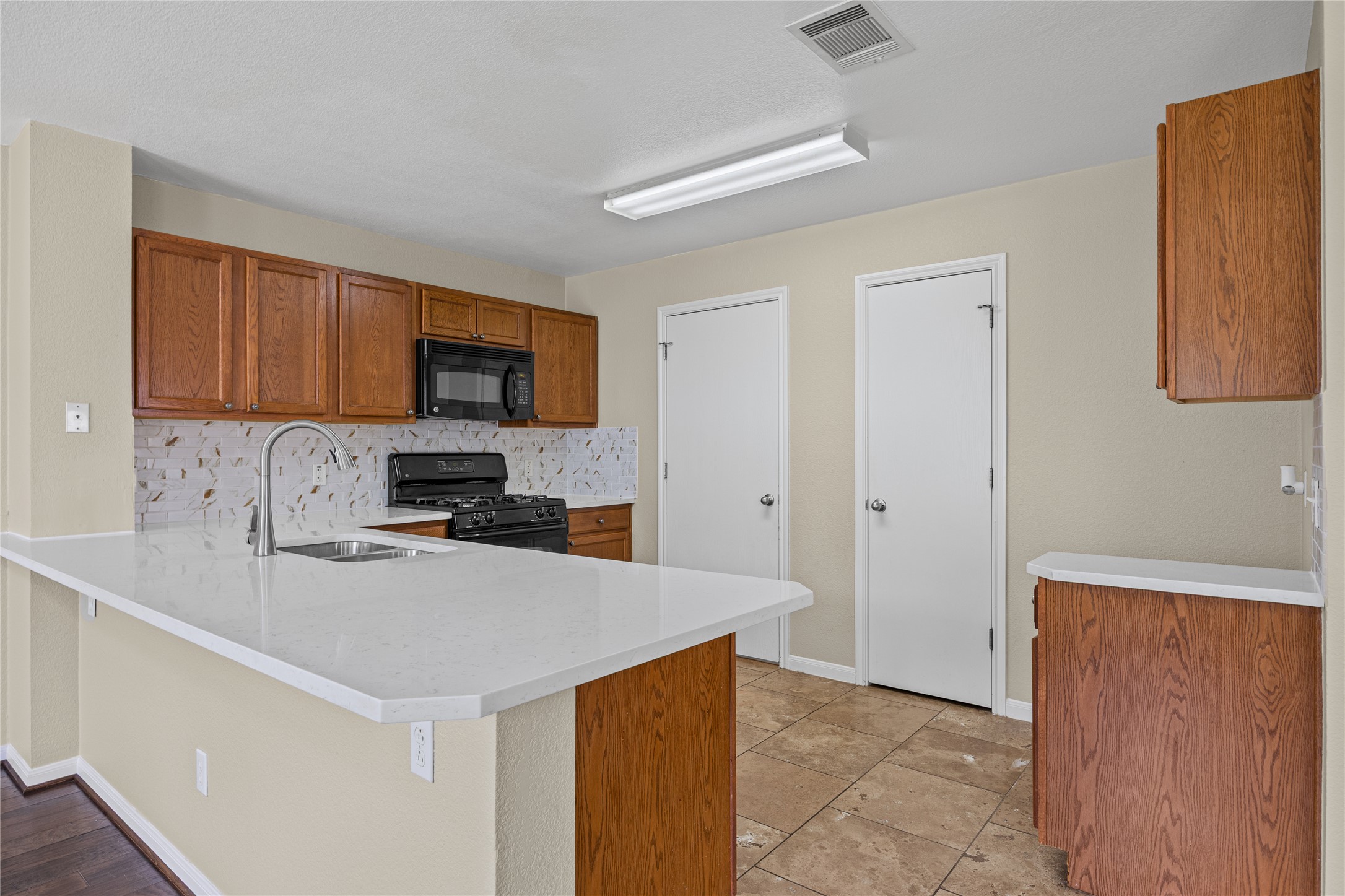198 Black Forest Road Buda, TX 78610 - Photo 6 of 23 A well-equipped kitchen features a breakfast bar and sleek countertops.