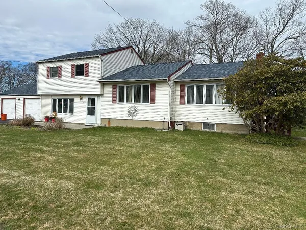 a front view of a house with a garden and trees