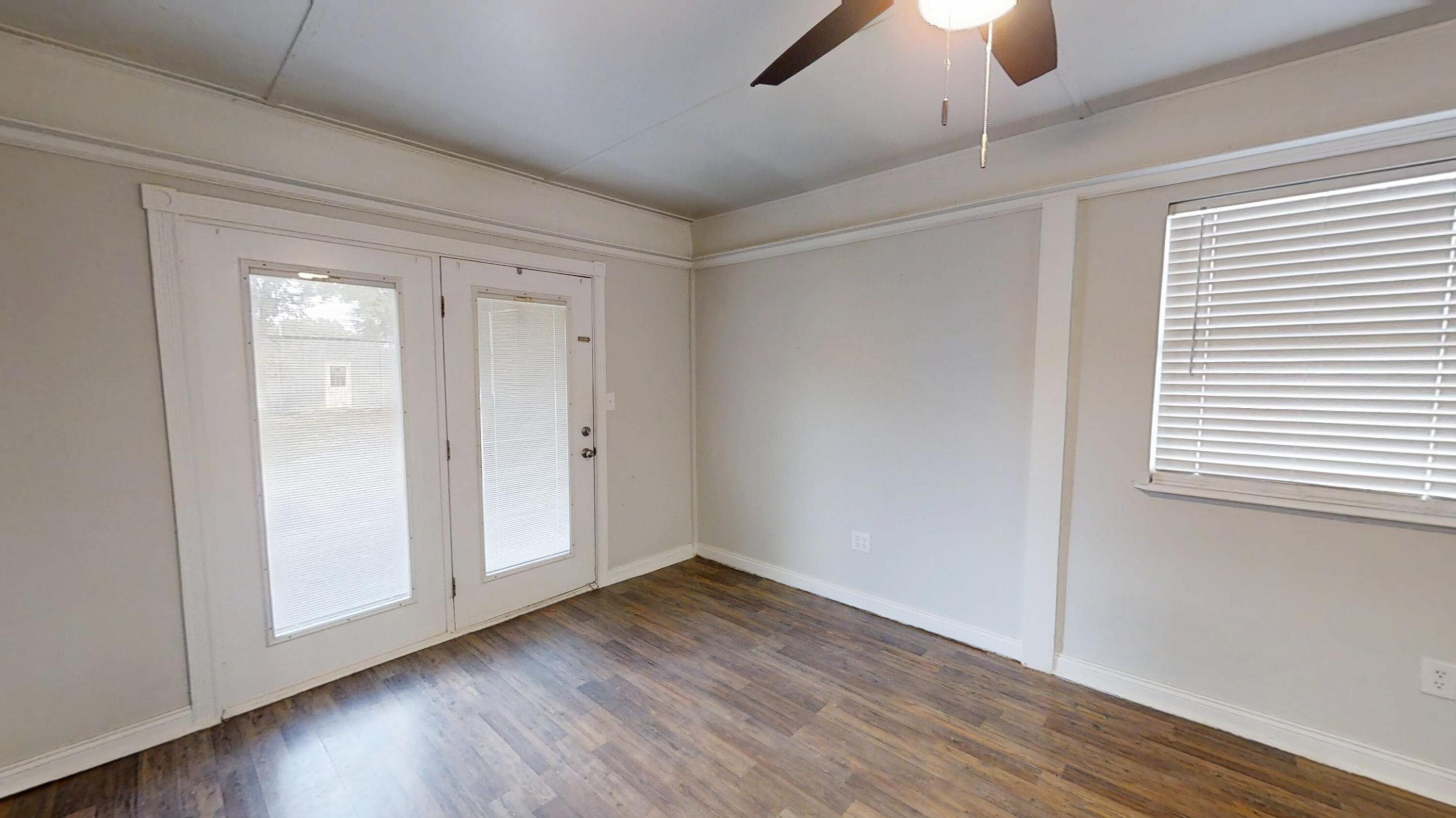 1202 Sunshine Drive Crestview, FL 32539 - Photo 11 of 38 a view of an empty room with wooden floor and a window