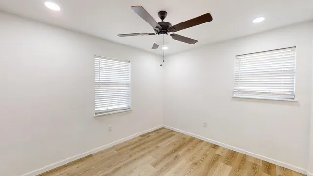 an empty room with a window and a ceiling fan