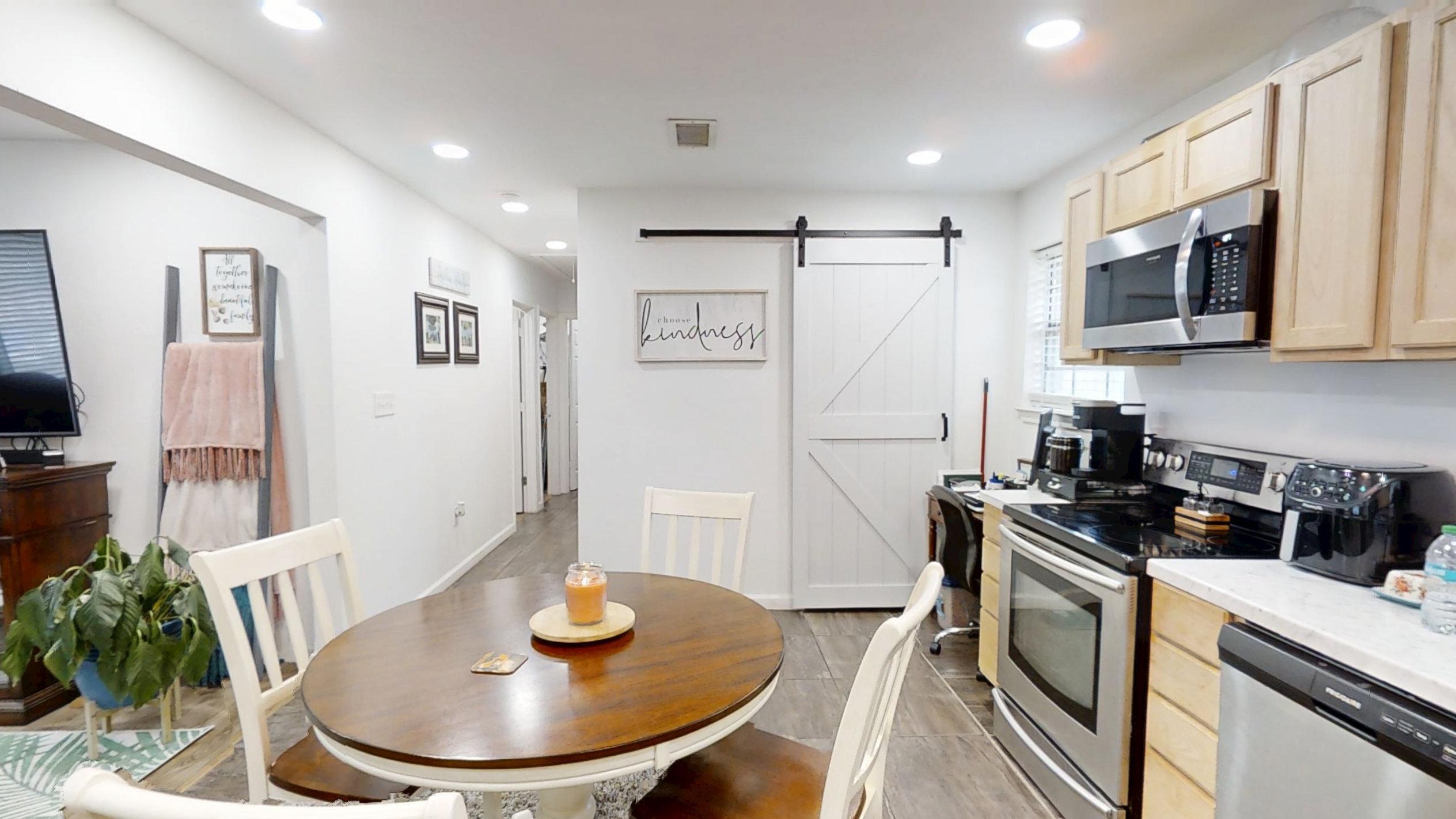 1202 Sunshine Drive Crestview, FL 32539 - Photo 24 of 38 a kitchen with stainless steel appliances a microwave a stove a table and chairs