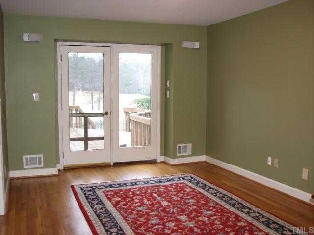 1409 Hunting Ridge Road Raleigh, NC 27615 - Photo 7 of 12 a view of an empty room with a window and wooden floor