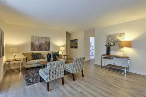 a living room with furniture and wooden floor