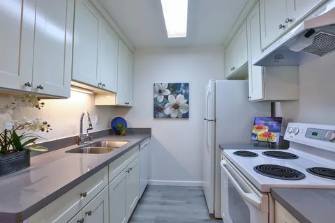 a kitchen that has a sink and a stove in it