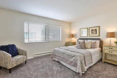 a bedroom with a bed couch and a window