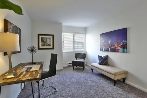 a living room with furniture a lamp and a window