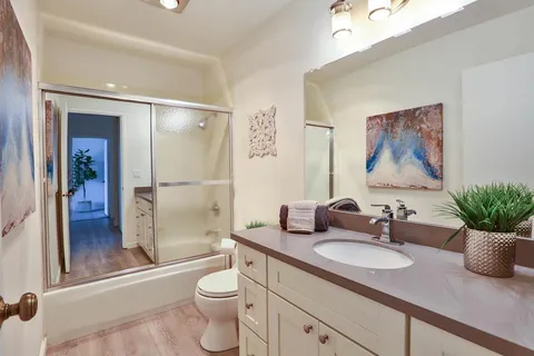 a bathroom with a granite countertop sink toilet and shower