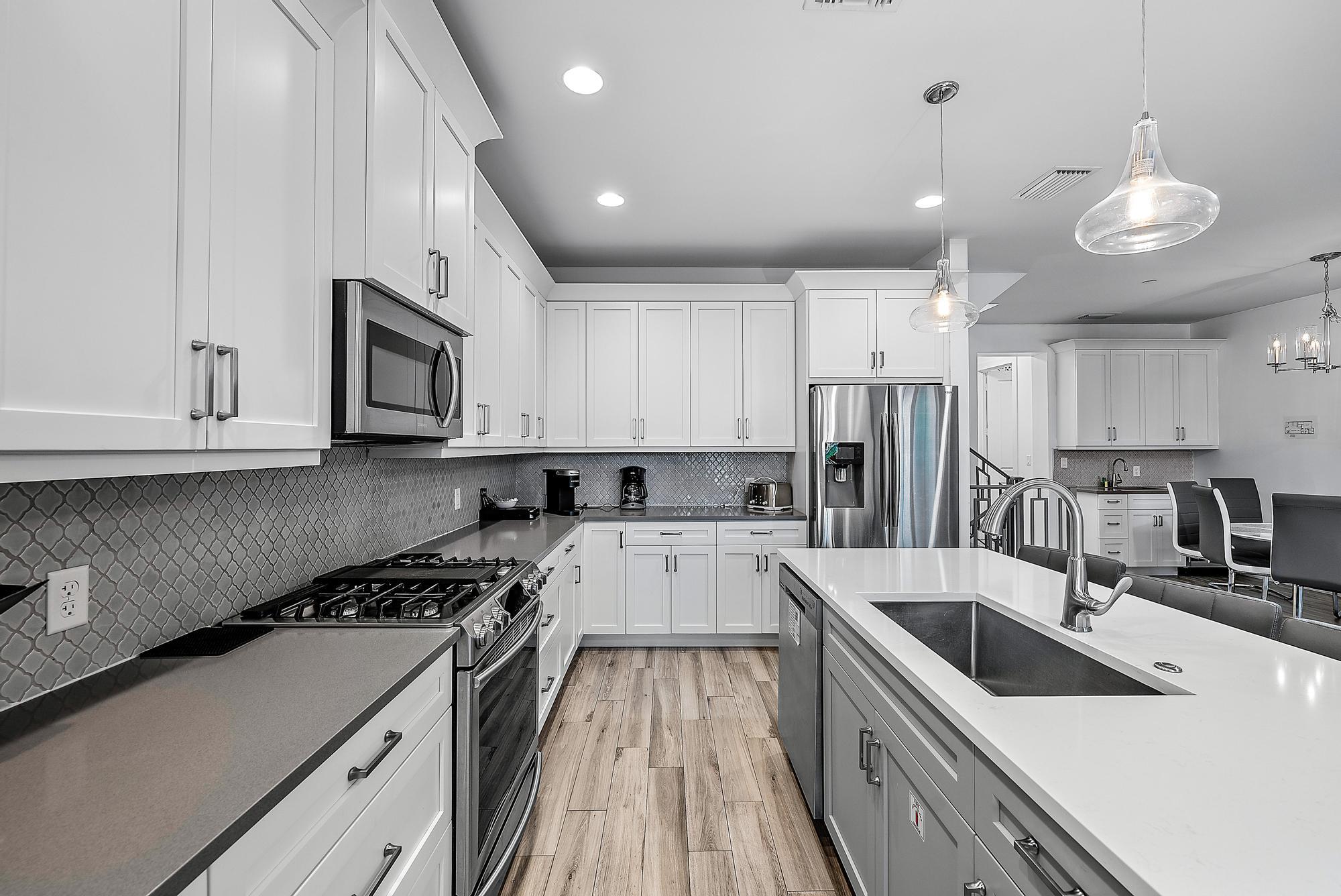 3770 County Line Road, Unit C6 Tequesta, FL 33469 - Photo 24 of 33 a kitchen with granite countertop a sink a counter top space stainless steel appliances and cabinets