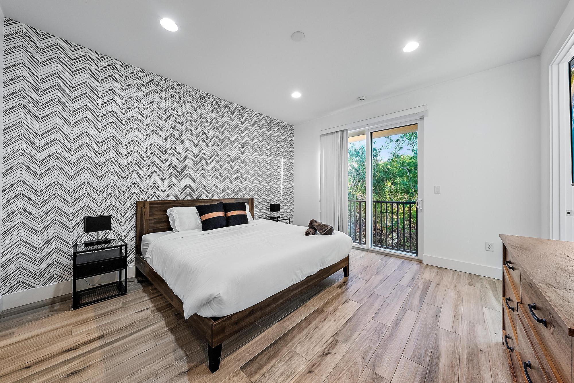 3770 County Line Road, Unit C6 Tequesta, FL 33469 - Photo 30 of 33 a large bedroom with a bed and wooden floor