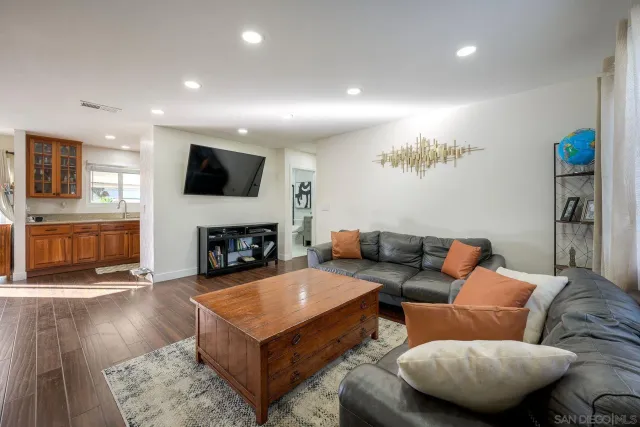 a living room with furniture a flat screen tv and a fireplace