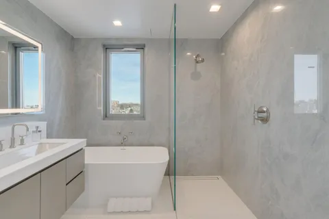 a bathroom with a bathtub a shower a sink and mirror