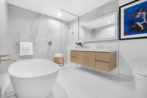 a bathroom with a tub sink toilet and mirror