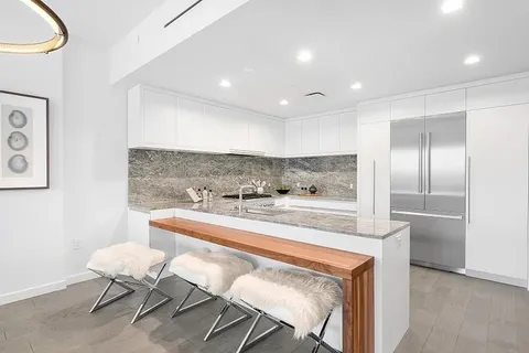 a kitchen with a dining table chairs and white cabinets
